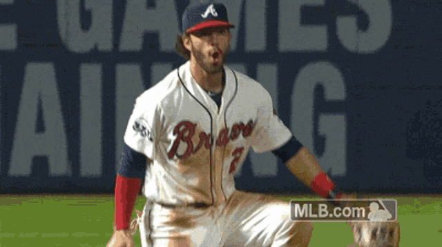 a man in a braves jersey is kneeling down