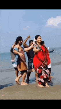 a group of people are standing on a beach .