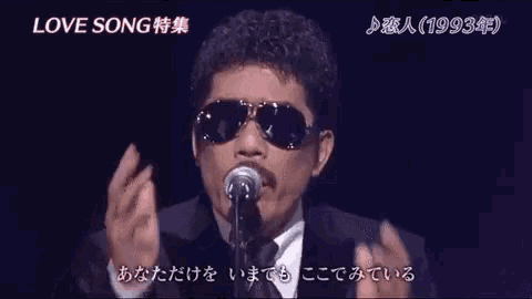 a man wearing sunglasses and a suit singing into a microphone with the year 1993 on the bottom