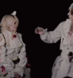 a woman in a white dress is being touched by another woman in a white dress