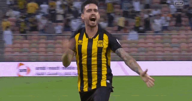 a soccer player wearing a yellow and black striped shirt with the letters htd on it