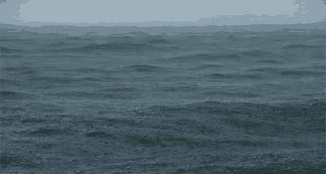 a large body of water with waves crashing on the shore