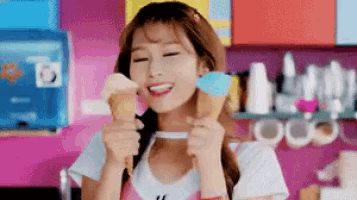 a woman is holding two ice cream cones in her hands .