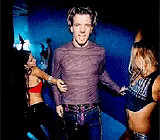 a man in a purple shirt stands between two women