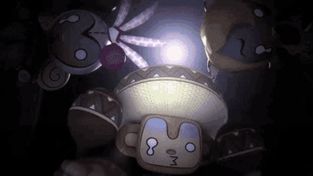 a group of stuffed animals are sitting next to each other in a dark room with a light shining on them .