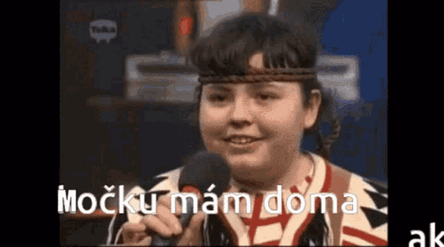 a young girl is holding a microphone and says mocku mam doma .