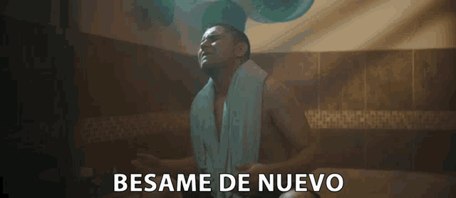 a man with a towel around his neck is singing in a bathroom and the words besame de nuevo are below him