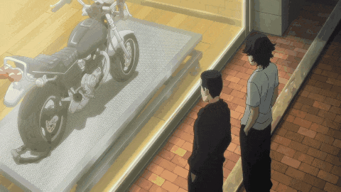 two men are looking at a motorcycle in a store window