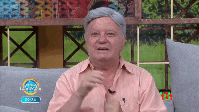 a man sits on a couch in front of a screen that says venga la alegria