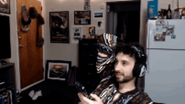 a man wearing headphones is looking at his phone in a living room
