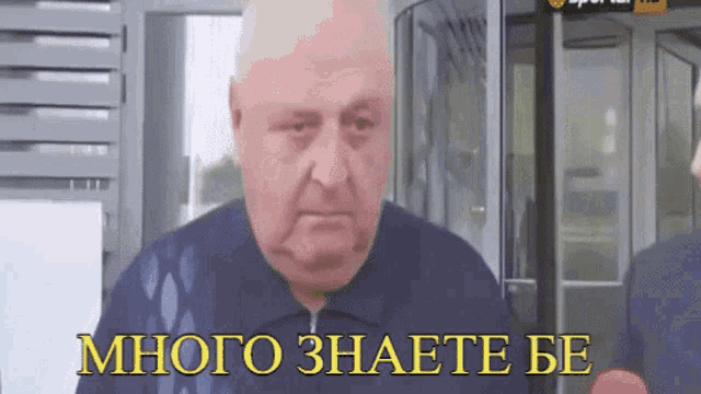 a man is standing in front of a glass door with the words много знаете be written on the bottom