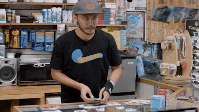 a man wearing a nike shirt is standing in front of a counter in a store