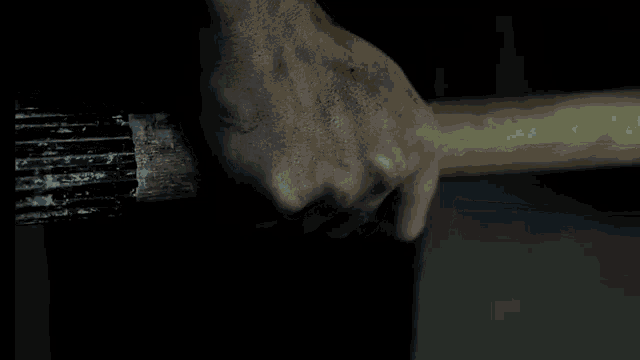 a close up of a person 's hand holding a stick