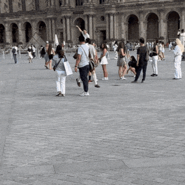 a group of people standing on a brick pavement in front of a building