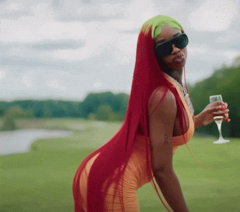 a woman with long red hair and sunglasses holds a glass of wine