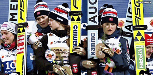 a group of skiers are posing for a photo and one of the skiers is wearing a namemo hat