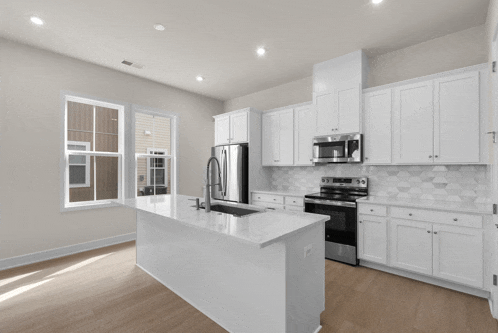 a kitchen with white cabinets stainless steel appliances and a sink
