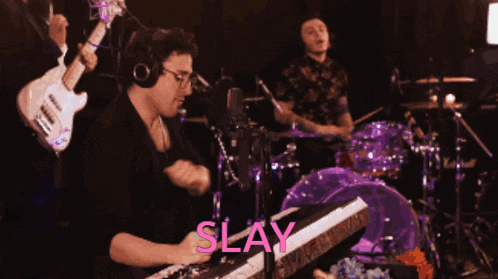 a man playing a keyboard with the word slay written on it