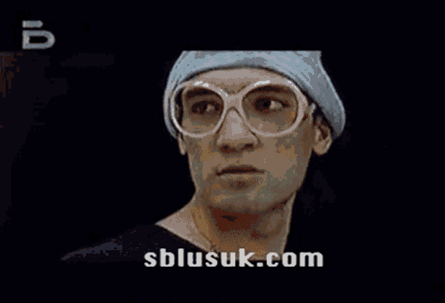 a man and a woman are kissing in a green screen with the website sblusuk.com in the corner .