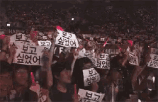 a crowd of people are holding up signs that say happy and zone