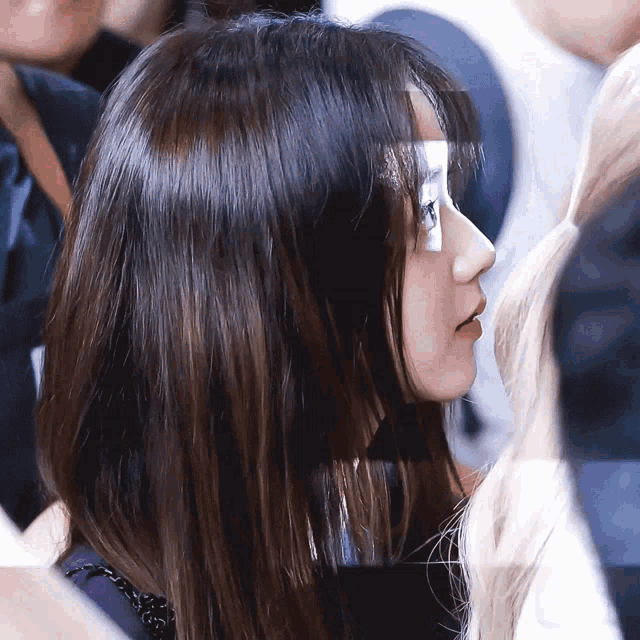 a close up of a woman 's face in a crowd of people