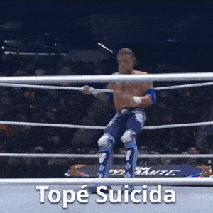 a wrestler is jumping in the air in a wrestling ring with the words tope suicida below him .