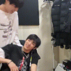 a man in a black shirt is sitting next to a man in a white shirt