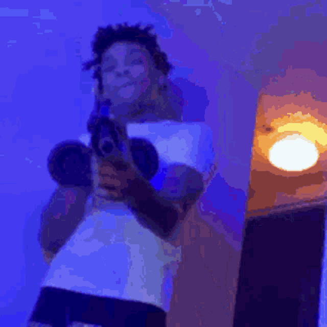 a person is laying on a bed in a room with purple lights .
