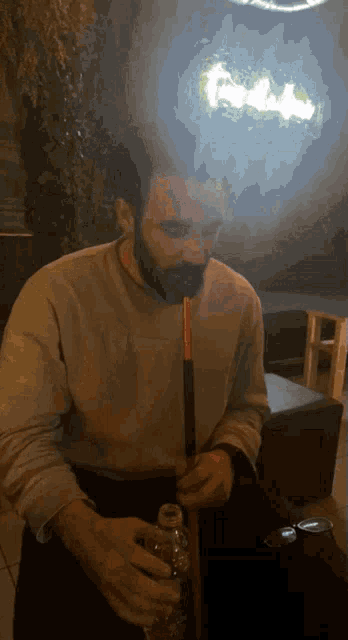 a man with a beard is smoking a hookah in front of a sign that says freedom