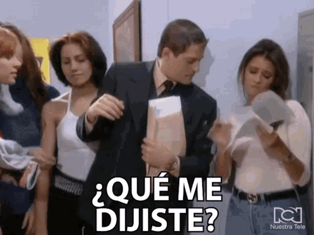 a group of people standing around a man holding a briefcase and a sign that says " que me dijiste "
