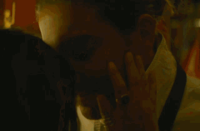 a close up of a man 's face with a white hat behind him