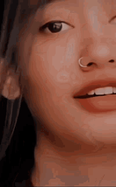 a close up of a woman 's nose with a nose ring .