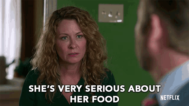 a woman talking to a man with the words she 's very serious about her food on the bottom