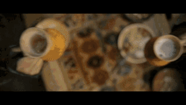 a blurred image of a table with coffee cups and saucers