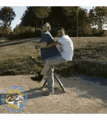 a man and a woman are riding a seesaw together in a park