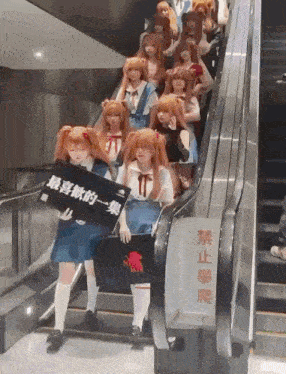 a group of people are riding an escalator and one of them is holding a sign that says ' evangelion ' on it