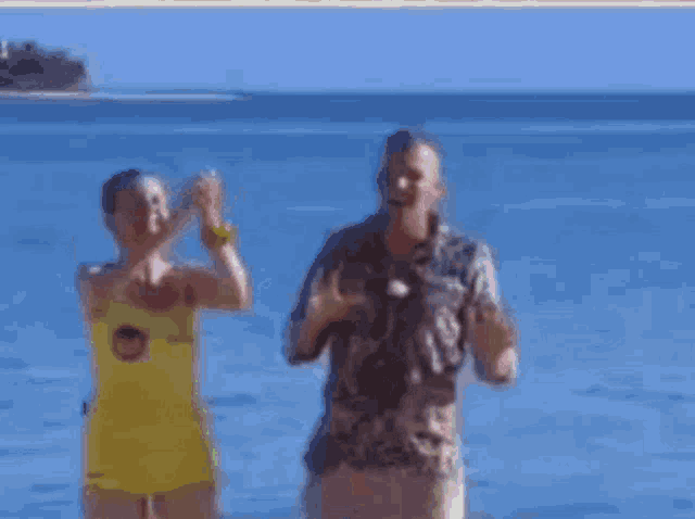 a man and a woman are dancing on a beach .