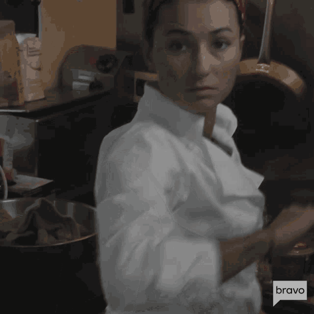 a woman in a chef 's coat is cooking on bravo