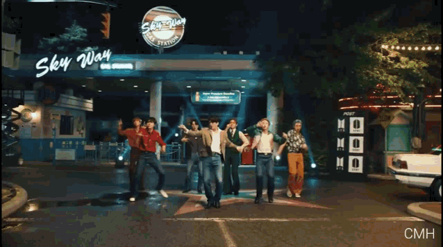 a group of people are dancing in front of a building that says sky way
