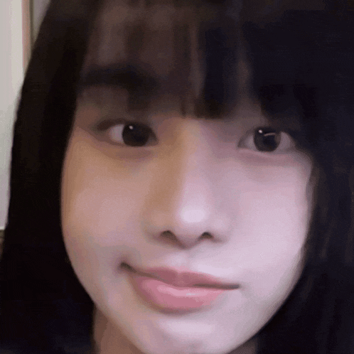 a close up of a young girl 's face with a blurred background