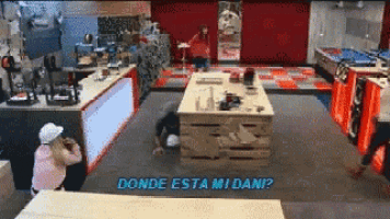 a man is laying on the floor in a kitchen with the words " donde esta mi dani " written on the bottom
