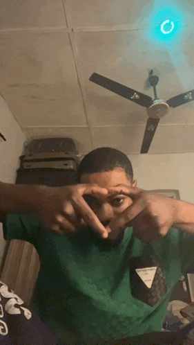 a man making a heart with his hands in front of his face