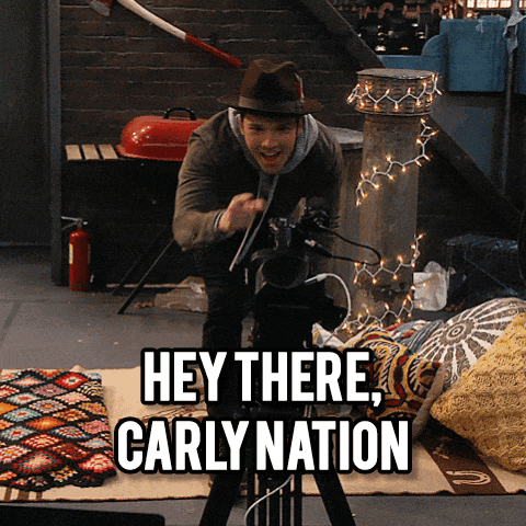 a man taking a picture with the words hey there carly nation above him