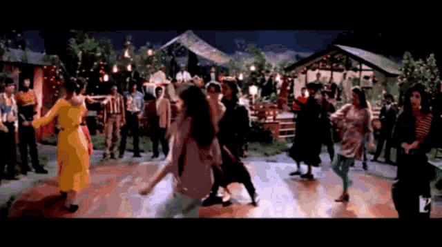 a group of people are dancing in front of a house