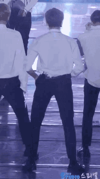 a man in a white shirt and black pants is dancing on stage