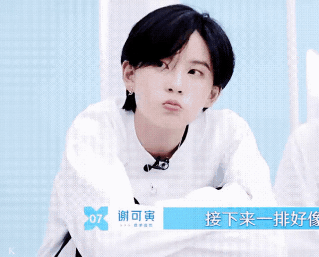 a girl with short black hair is wearing a white shirt with the number 07