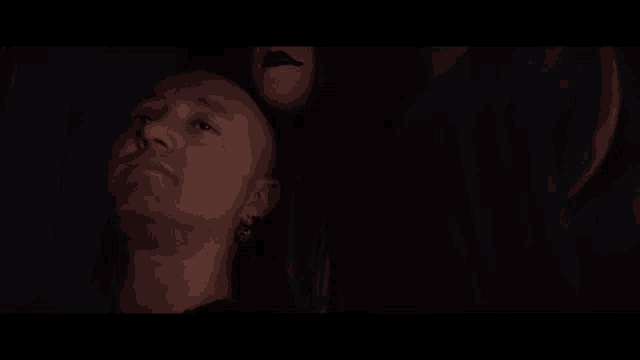 a man is laying in a dark room with the words `` maybe '' written above him .