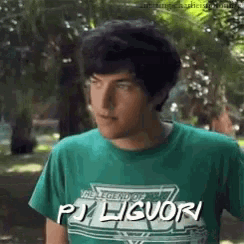 a young man wearing a green shirt that says pj liquor on it