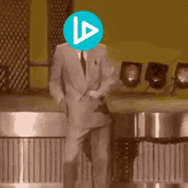 a man in a suit and tie is dancing with a blue circle with a play button on it
