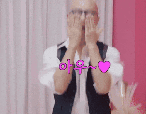 a bald man wearing glasses and a white shirt is smiling in front of a pink wall .